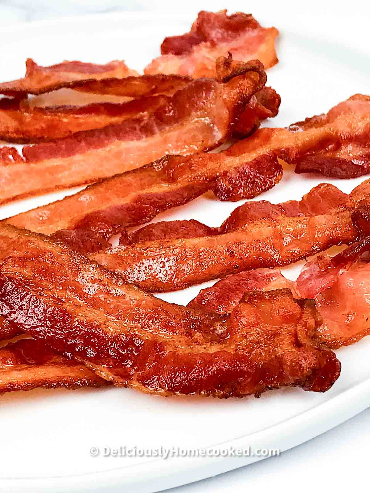 Close shot of cooked bacon on a white plate